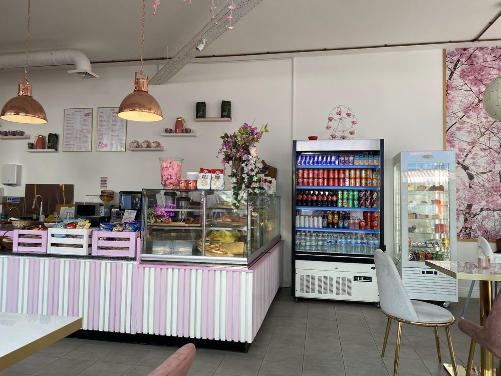 The service counter with its glass cake display, drinks fridge and pendant lights.