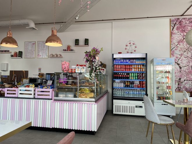 The counter, cake display and pendant lights seen across the room.