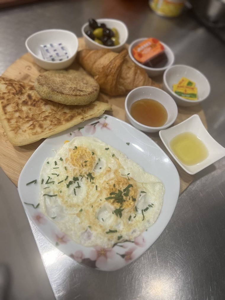 Middle Eastern breakfast spread for sharing, with eggs, flatbread, olives, labneh, jam and honey.