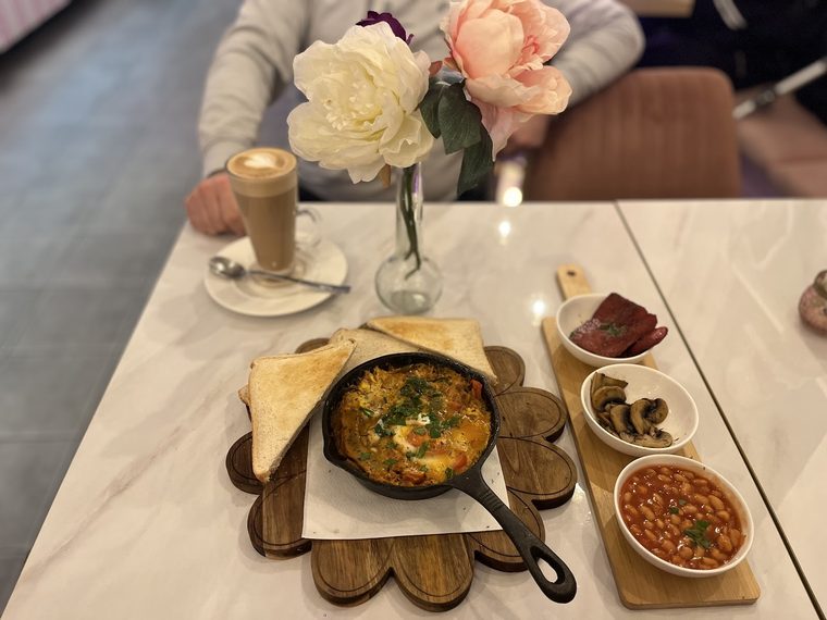 Shakshuka-style skillet served with olives, beans and coffee.