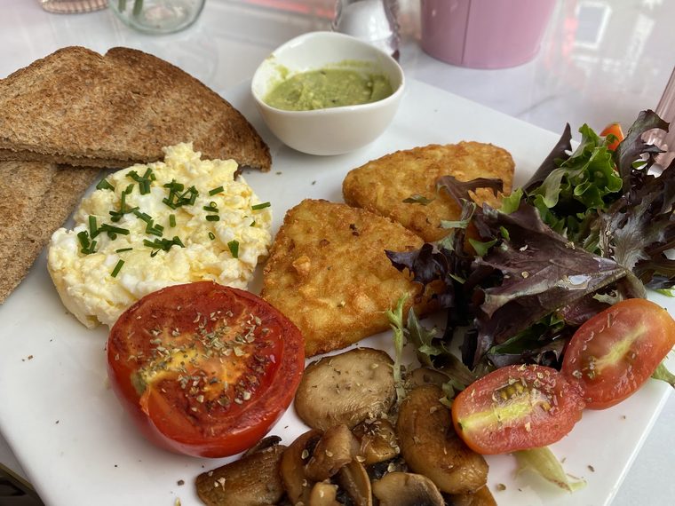 Scrambled eggs with pitta, hash browns, mushrooms and a pot of green dip.